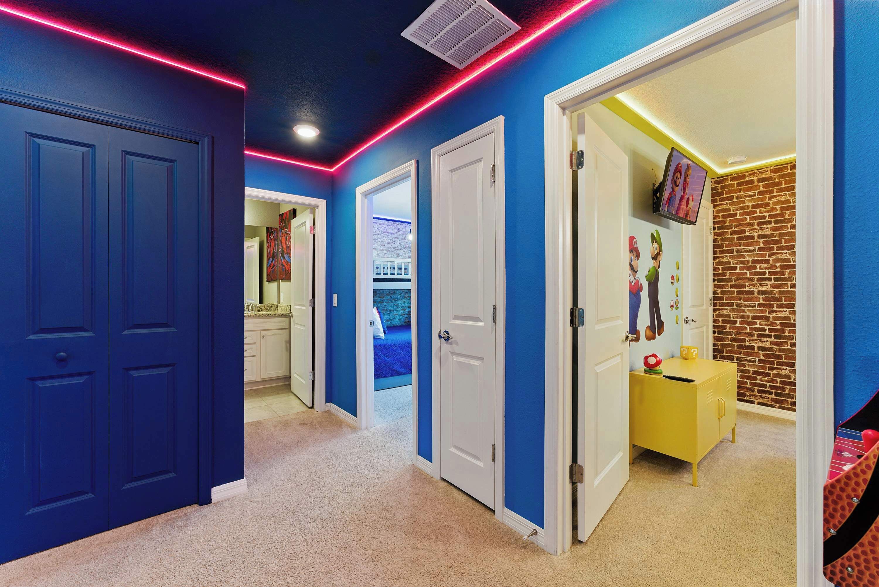 A hallway with blue walls, white doors, and a yellow cabinet.