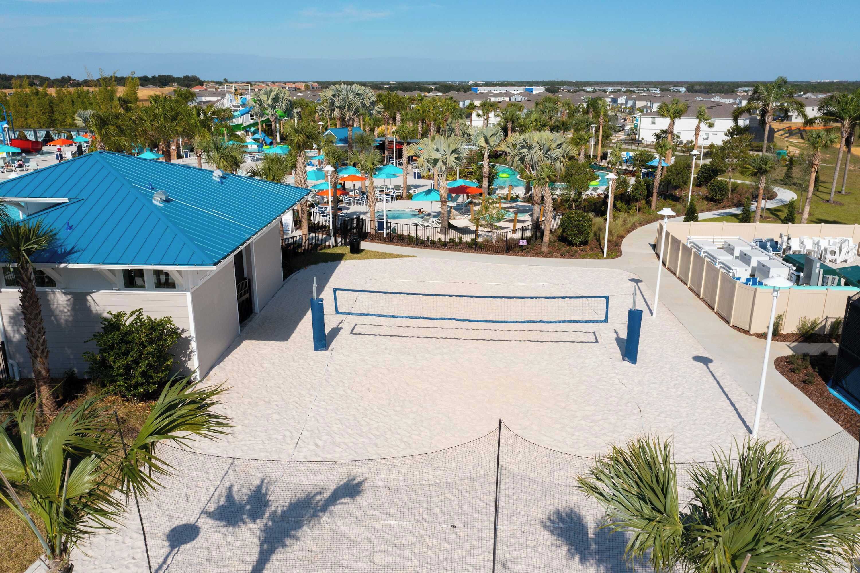 A resort with a pool area, palm trees, and a view of the surrounding landscape.