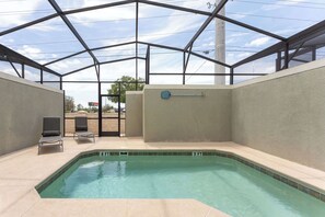 A swimming pool with a 4 ft depth marker, two lounge chairs, and a covered area with a metal roof structure. - Relax Near Disney, 4BR Home With Pool (Kissimmee)