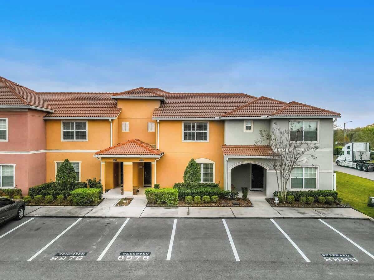 A multi-story building with a parking lot in front.