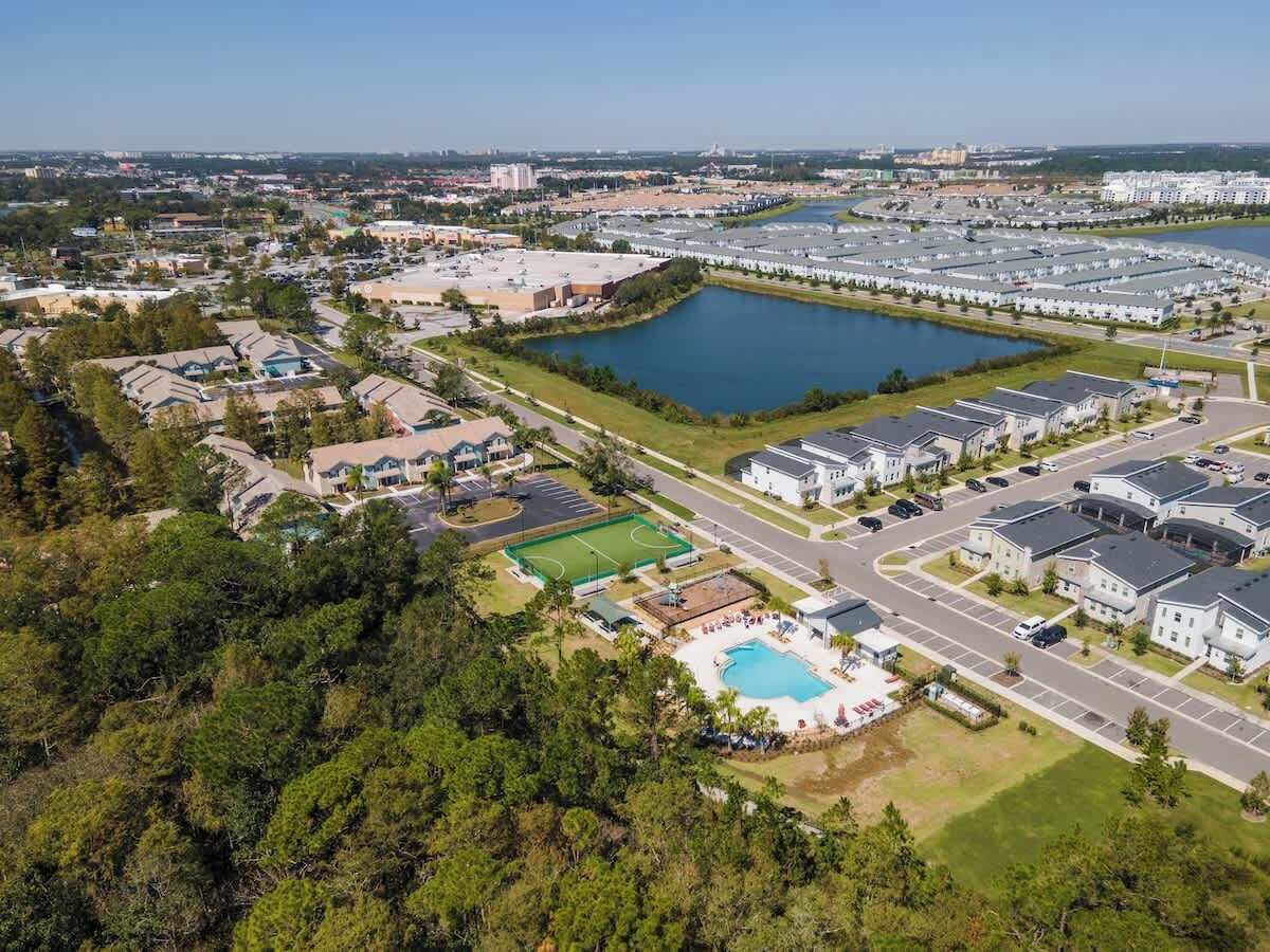 Vista aérea de una zona residencial con una gran piscina, varios edificios y una masa de agua.