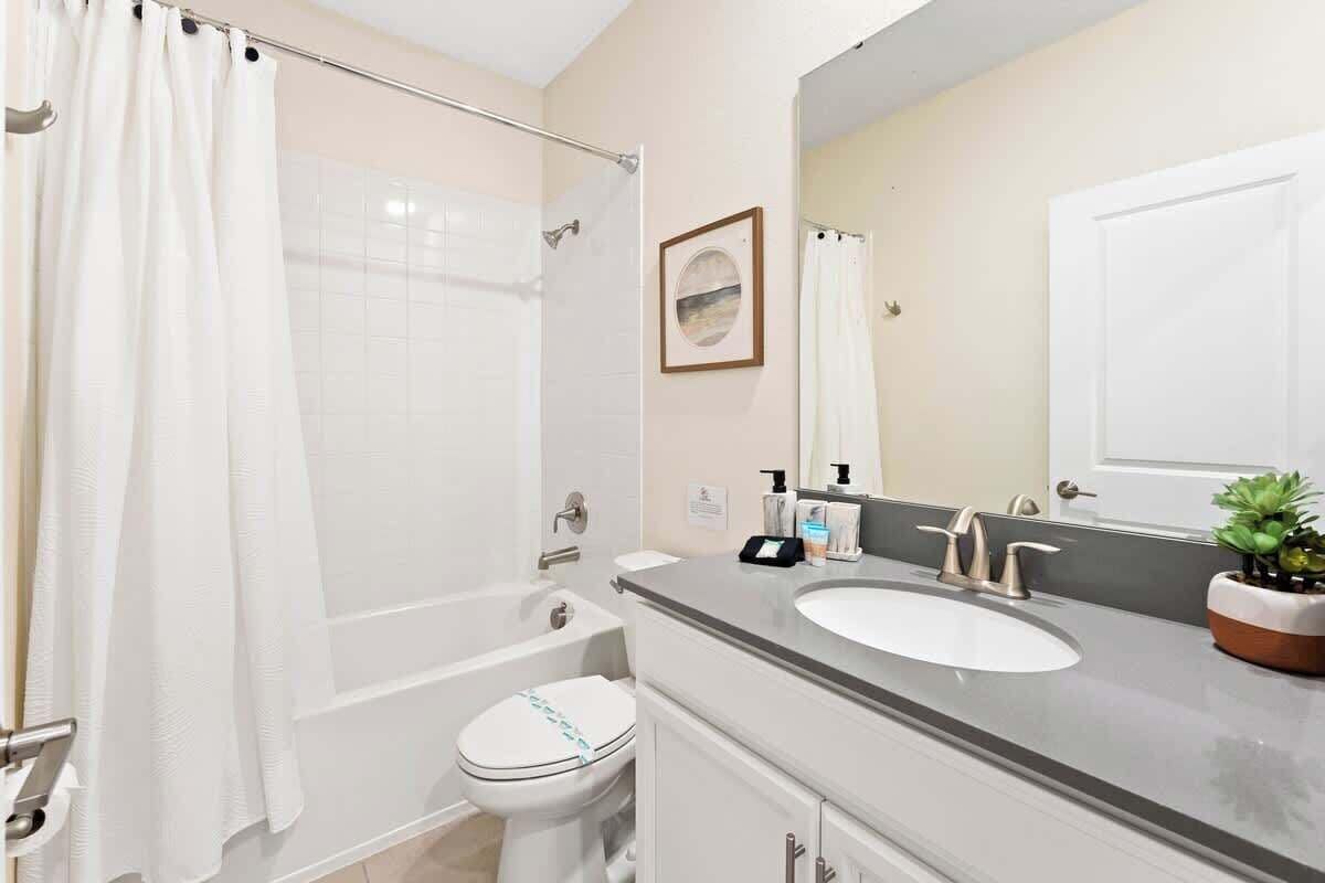A bathroom with a bathtub, toilet, and sink.