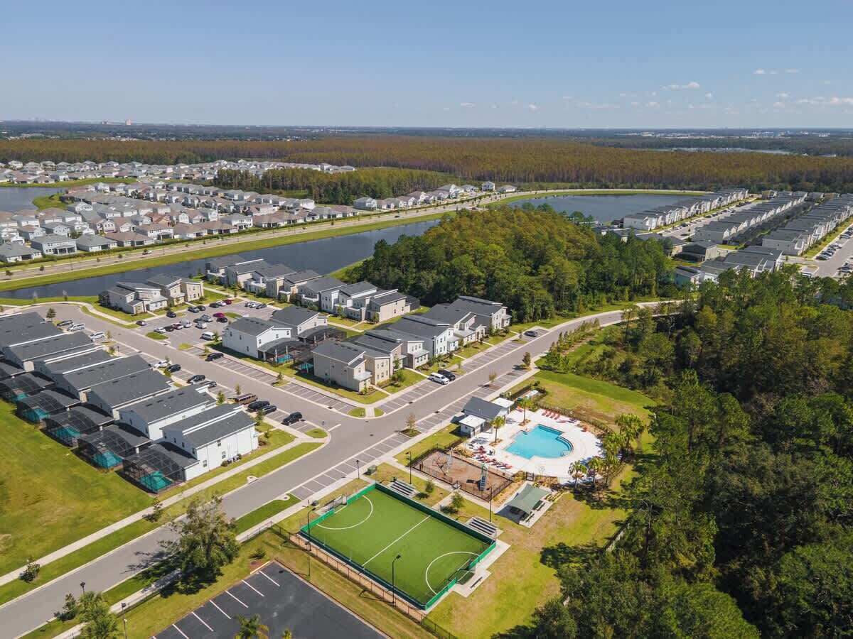 Vista aèria d'una zona residencial amb diversos blocs d'apartaments, una piscina i un camp esportiu.