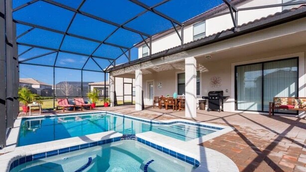 A swimming pool with a glass ceiling, outdoor seating, and a patio area. - Spacious 5br, Private Pool, Beautiful Decor (Davenport)
