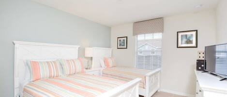 A bedroom with a bed, bedside tables, a dresser, a television, and a window with blinds.