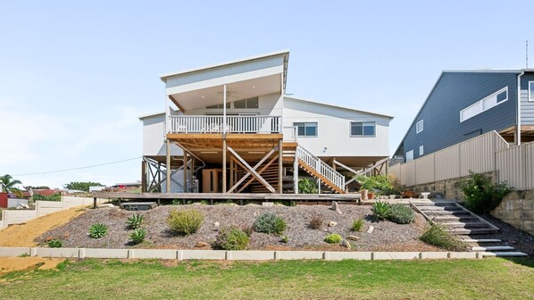 A modern two-story house with a wooden deck and a balcony. - Scarp n Sea – Sauna, Views & Serene Coastal Escape (Falcon)
