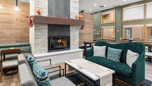 Ein moderner Lounge-Bereich mit Kamin, bequemen Sitzgelegenheiten und einem Essbereich.