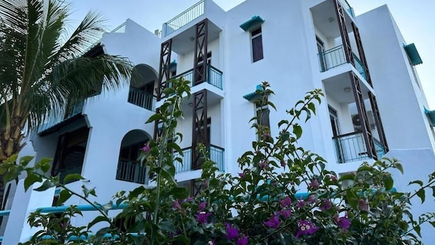 Un immeuble à plusieurs étages doté de balcons et de fenêtres en arc de cercle.