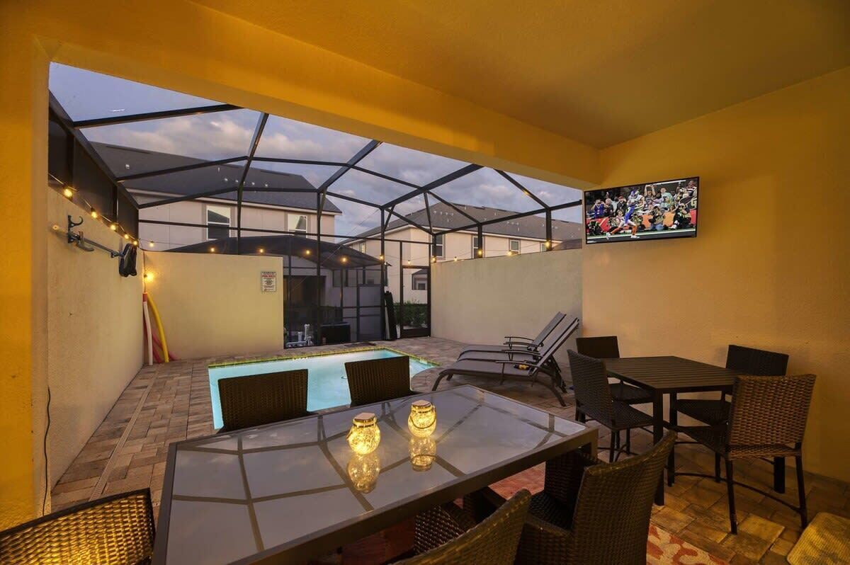 A rooftop terrace with a glass enclosure, a pool, and outdoor furniture.