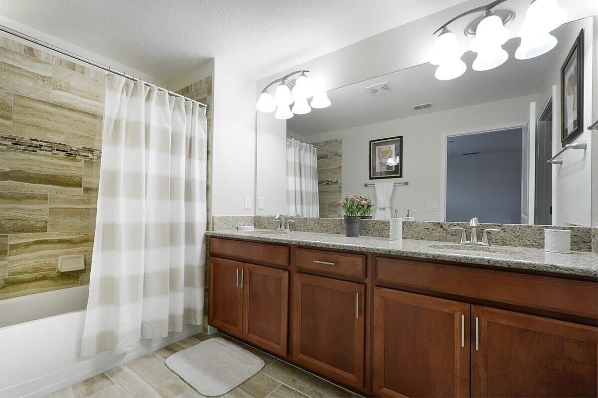 Une salle de bain avec une douche, un meuble-lavabo avec un miroir et un évier.