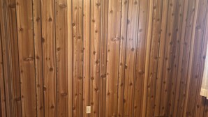 A room with wooden panel walls and a wooden floor. - Monthly Rentals (Edmonton)