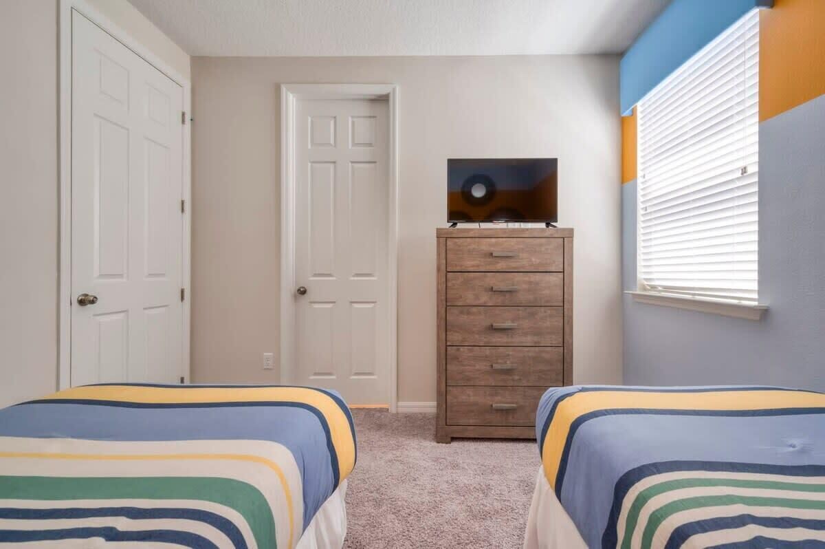 Ein Schlafzimmer mit zwei Betten, einem Schminktisch und einem Bild an der Wand.