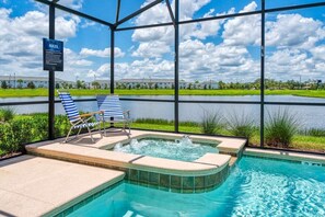 A pool area with lounge chairs, a hot tub, and a sign indicating pool rules. - Stunning Home, Private Pool, Great Location (Kissimmee)