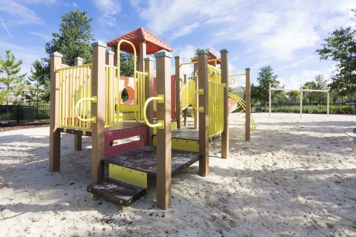 A playground with a slide, climbing structures, and a sandpit.