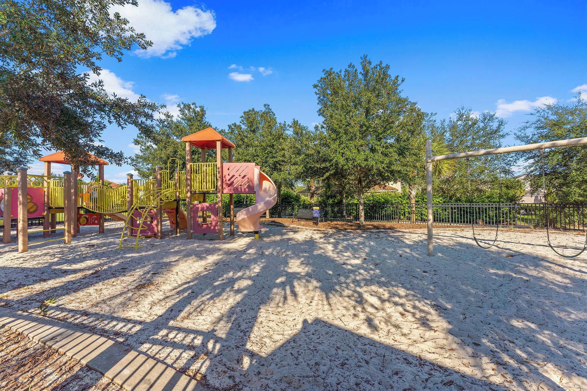 A playground with a slide, climbing structures, and a swing set.