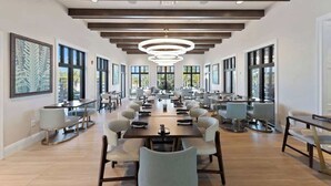 A spacious conference room with long tables and chairs, large windows, and a modern chandelier. - Stunning 7BR Home With Themed Bedrooms (Kissimmee)