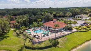 Eine Luftaufnahme eines Resorts mit Schwimmbad, Palmen und einem Wasserabschnitt.