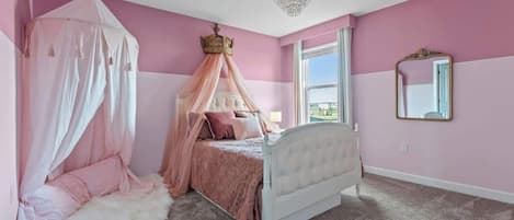 A bedroom with a canopy bed, a large window, and a chandelier.