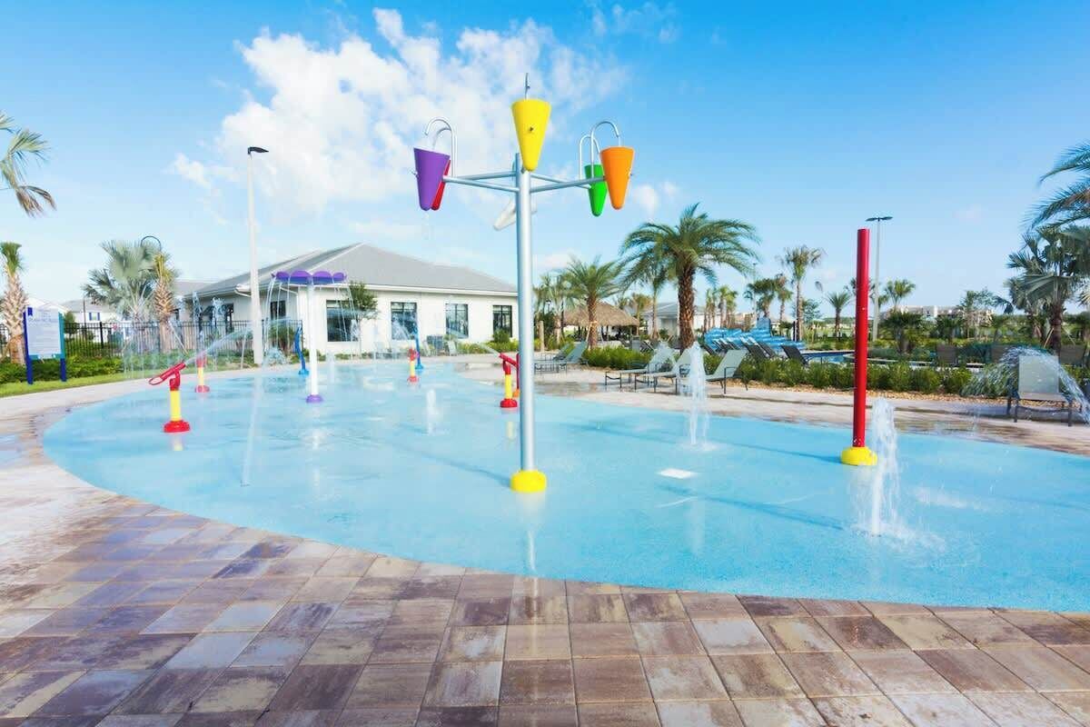 Un área de juegos acuáticos con múltiples chorros de agua y cubos de colores.