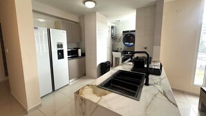 A modern kitchen with a built-in oven, a microwave, and a stainless steel sink. - Fabulous 5-bedroom apartment with AC in vibrant Panamá (Panamá)