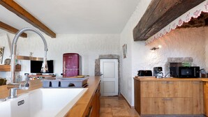 Una cocina con encimera de madera, un electrodoméstico rojo y una puerta blanca.