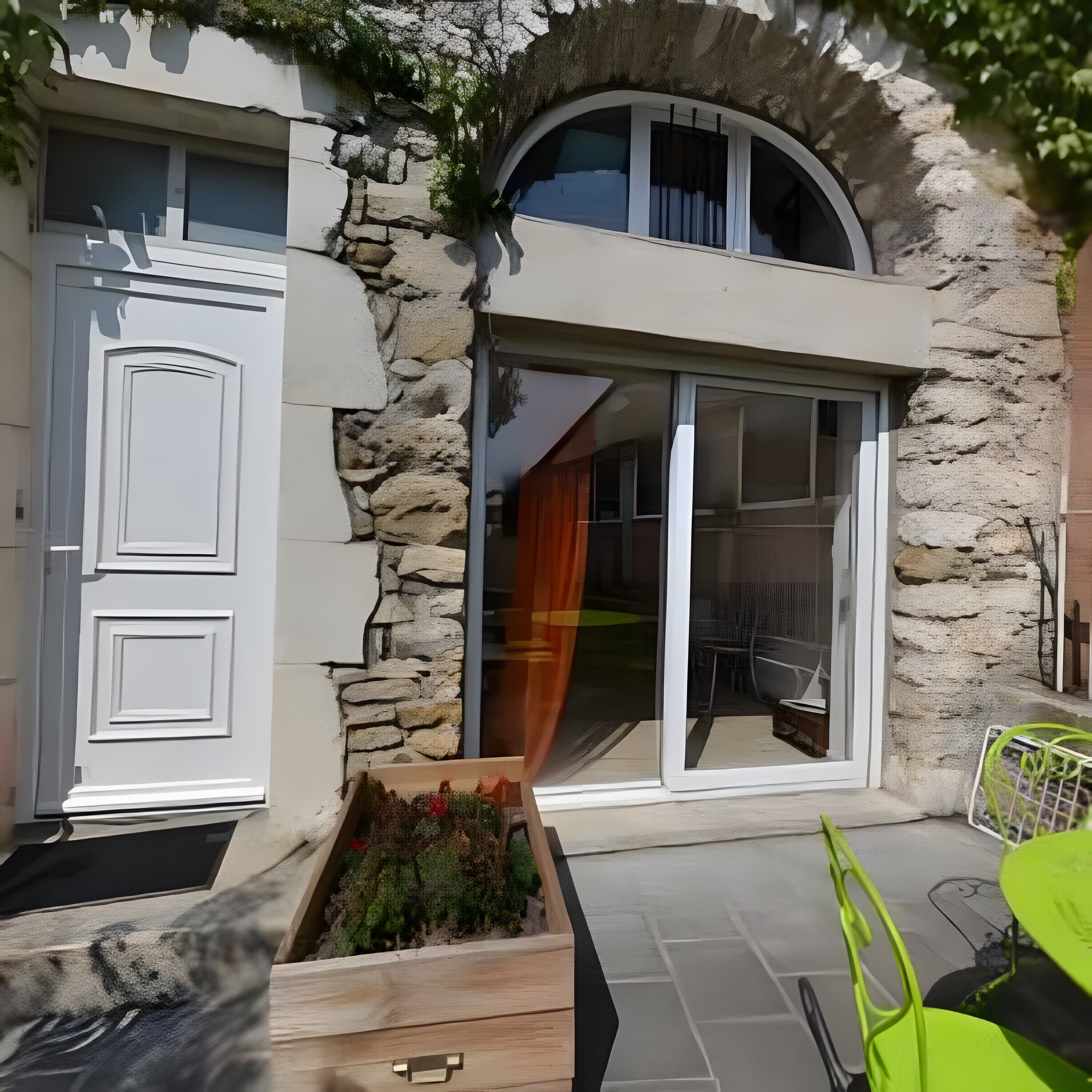Un edificio moderno con facciata in pietra, una porta bianca e un ingresso in vetro.