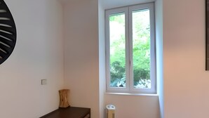 A room with a window, a wooden dresser, a white radiator, and a bed. - Gîte '03' with Wi-Fi (Vallon-Pont-d'Arc)