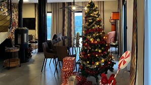 Ein Wohnzimmer mit Weihnachtsbaum, Geschenken und einem Kamin.