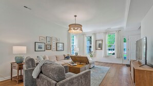 Un salón amplio con sofá, mesa de centro y un mueble de madera.