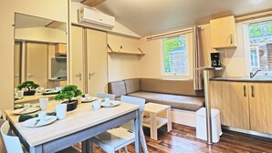 Une cuisine compacte comprenant un coin repas, un banc intégré et une petite table.