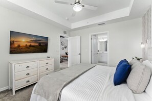 A bedroom with a bed, a dresser, a painting, and a ceiling fan. - Last Minute Disney! Luxury Condo with Balcony. Book Now! #SLR561 (Orlando)