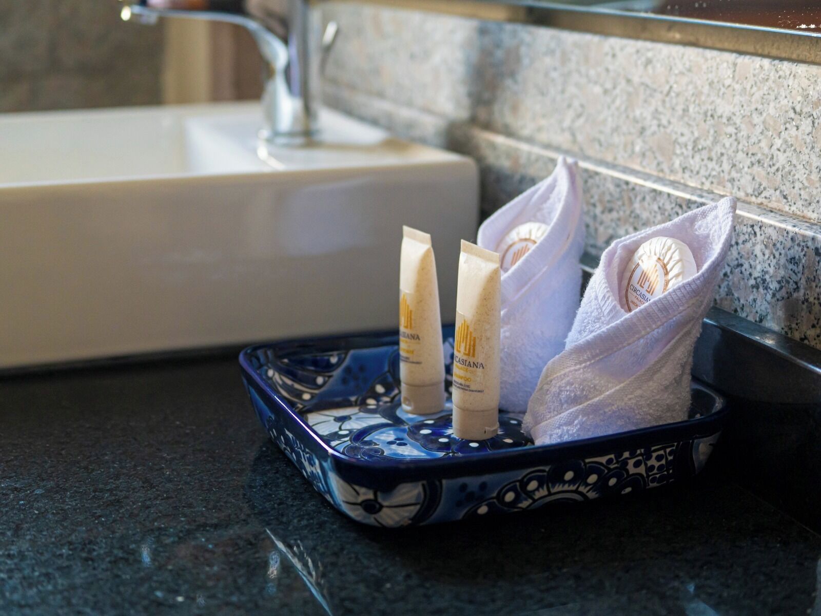 Ein Badezimmerwaschbecken mit einer blauen Ablage für Toilettenartikel.