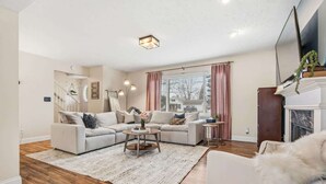 A spacious living room with a sectional sofa, a round coffee table, and a fireplace. - 4 BR - Hot Tub-Game Room-Near MGM-Sleeps 8 (Northfield)