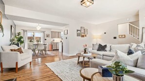 A spacious living room with a dining area, a kitchen, and a staircase leading to an upper floor. - 4 BR - Hot Tub-Game Room-Near MGM-Sleeps 8 (Northfield)