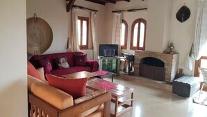 Un salon chaleureux avec une cheminée, des meubles en bois et un téléviseur.