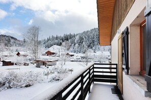 Un paisaje nevado con casas y un edificio de madera con balcón.