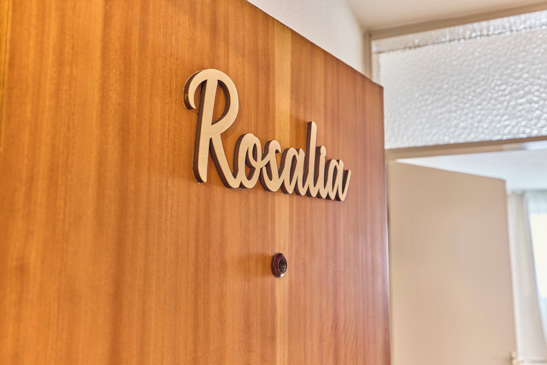 Una puerta de madera con una placa que dice "Rosalia".