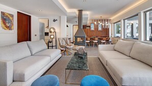 Un salon moderne avec un canapé, une table basse et une cheminée.