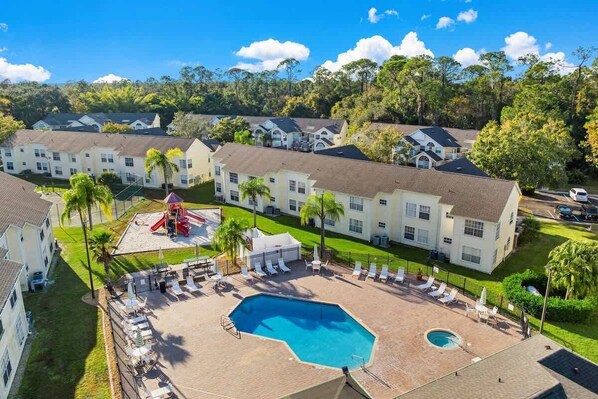 A residential area with multiple houses, a swimming pool, and a playground. - Resort Pool*Renovated*Near Parks! (Kissimmee)