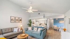 Ein Wohnzimmer mit einer Couch, einem Couchtisch und einem Essbereich mit Tisch und Stühlen.