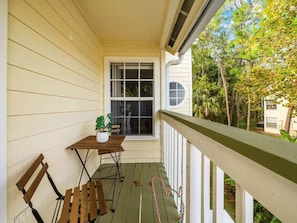 A porch with a wooden table and chairs, a potted plant, and a window. - Resort Pool*Renovated*Near Parks! (Kissimmee)