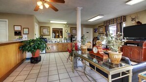 A spacious living area with a kitchen, a dining table, and a television. - Oak Tree Inn (Durant)
