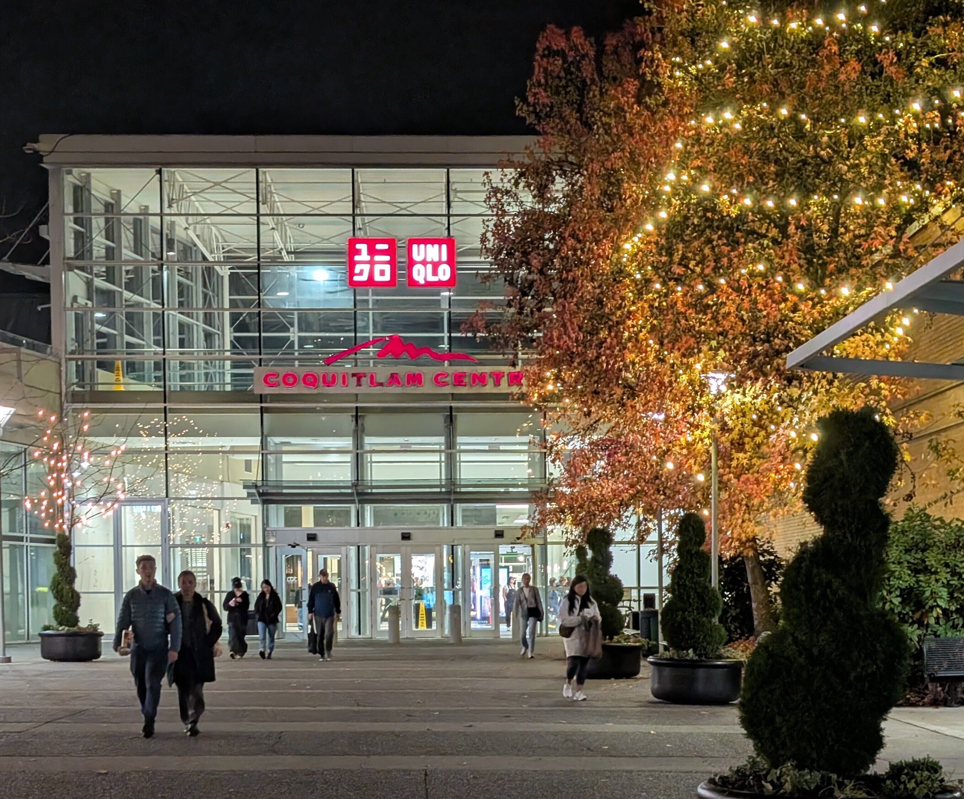A building with a glass facade and a sign reading "COQUITLAM CENTER".