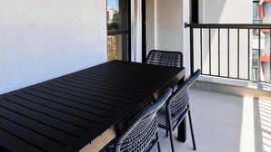 A balcony with a wooden ceiling, a table, and two chairs. - Update Vila Madalena by Wecare Hosting (São Paulo)