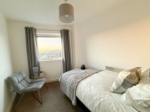 Tabla de planchar con plancha, internet y ropa de cama 