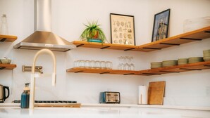 Eine Küche mit Holzböden, einem Gasherd, einem Toaster und einer hängenden Pflanze.