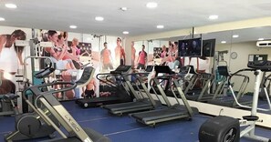 A gym with multiple treadmills, exercise bikes, and a mirrored wall. - Marulhos Suítes Resort (Ipojuca)