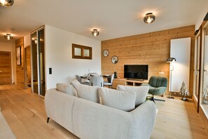 Ein modernes Wohnzimmer mit einer Couch, einem Fernseher und einer Holzwand.