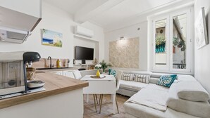 A modern living space with a kitchen, dining area, and seating area. - L'Azur Antibois – Charme & confort dans le Vieil Antibes (Antibes)