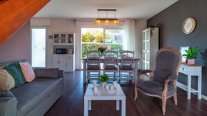 Een moderne woonkamer met een trap, een eethoek en uitzicht op het buitengebied.